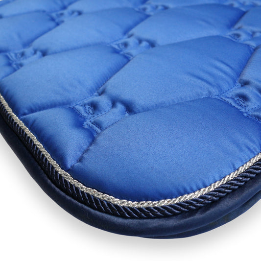 Close-up of a blue quilted saddle pad with a white background
