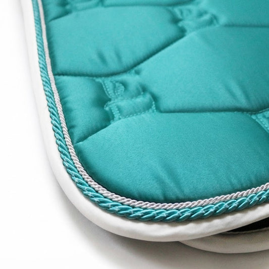 Close-up of a teal saddle pad with white trim on a white background